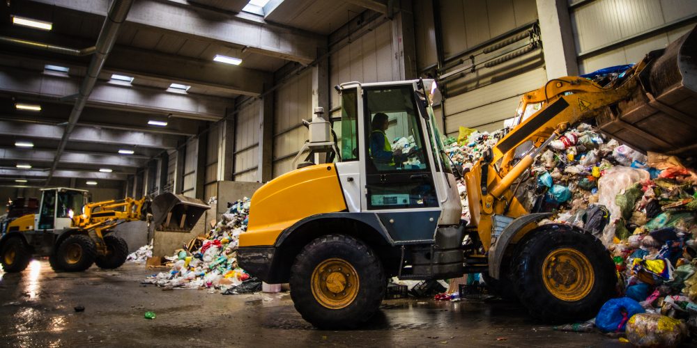 Earth mover in the garbage dump with female driver